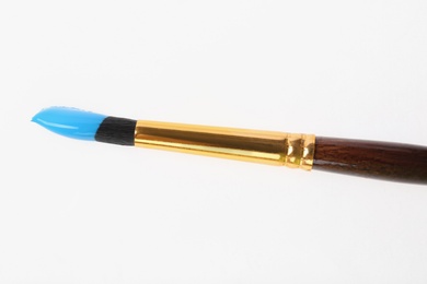 Photo of Brush with color paint on white background, top view