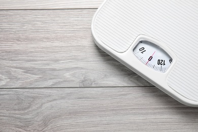 Scales on wooden background, top view with space for text. Weight loss