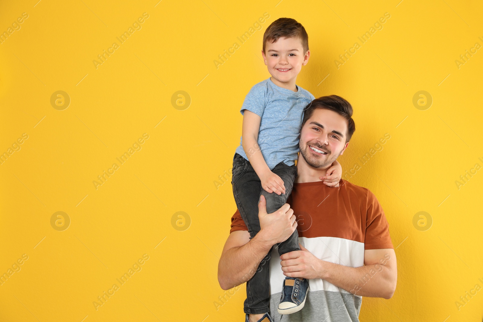 Photo of Portrait of dad and his son on color background. Space for text