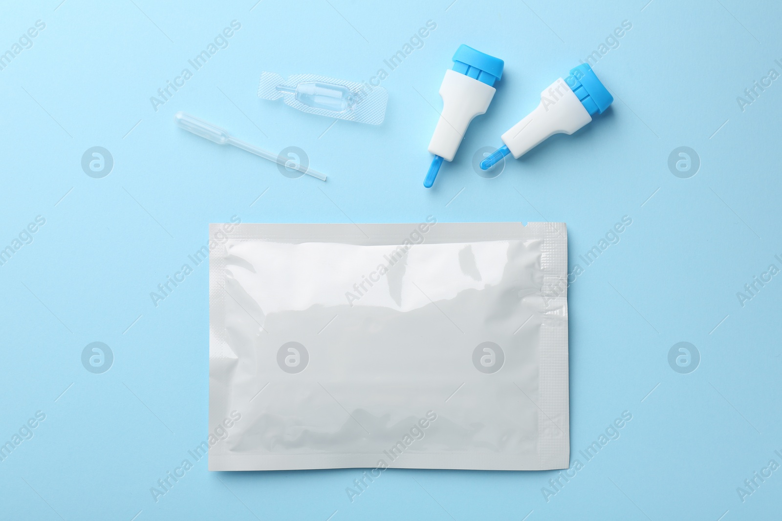 Photo of Disposable express test kit on light blue background, flat lay