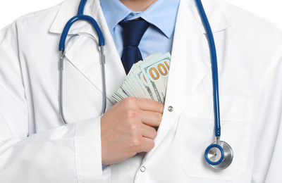 Photo of Doctor putting bribe into pocket, closeup. Corruption in medicine