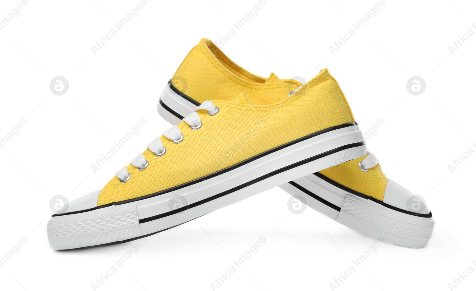 Photo of Pair of yellow classic old school sneakers on white background