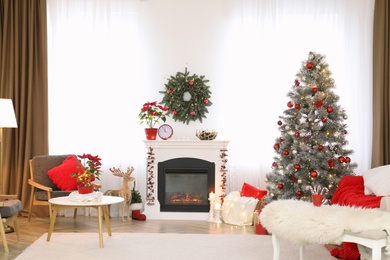 Beautiful living room interior with burning fireplace and Christmas tree