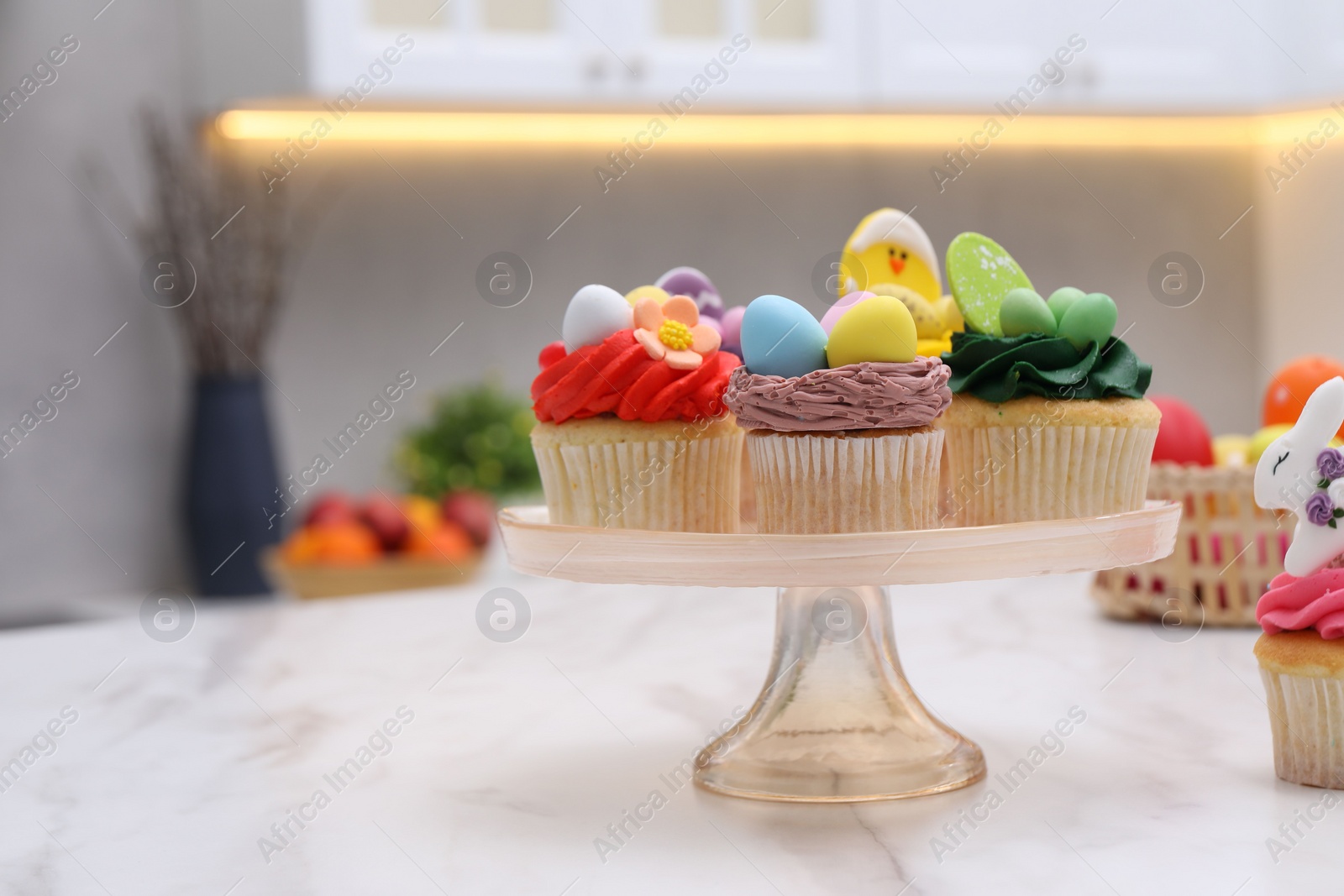 Photo of Tasty decorated Easter cupcakes on white marble table, space for text