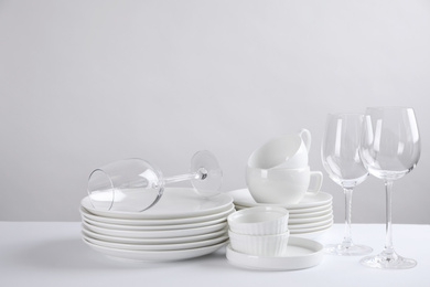 Photo of Set of clean dishes on white table