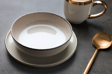 Photo of Stylish empty dishware and spoon on grey table, closeup