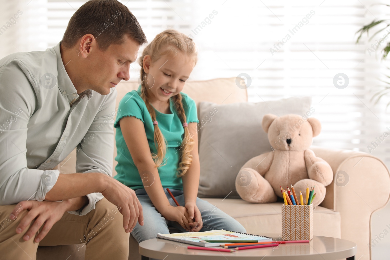 Photo of Child psychotherapist working with little girl in office