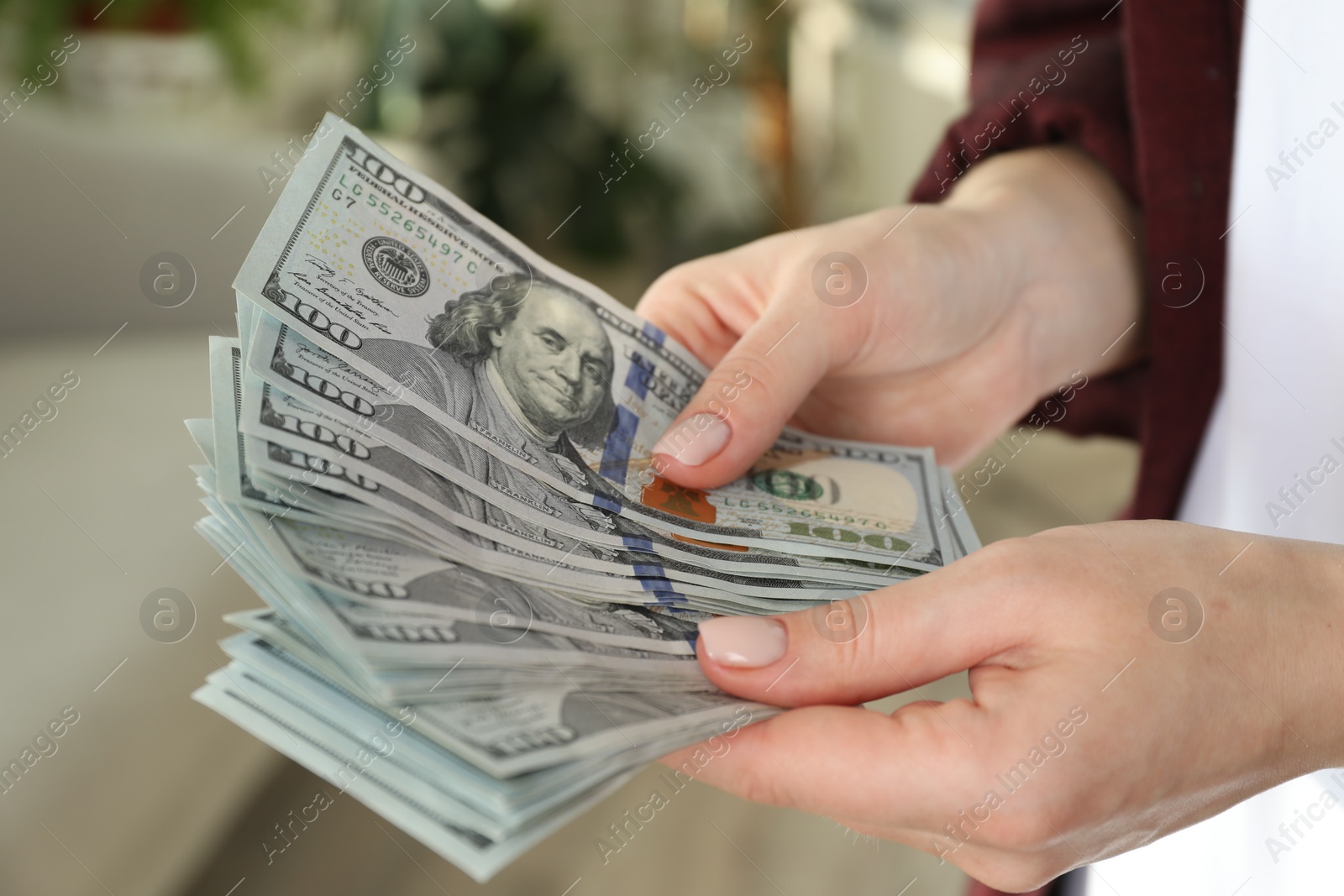 Photo of Money exchange. Woman counting dollar banknotes on blurred background, closeup