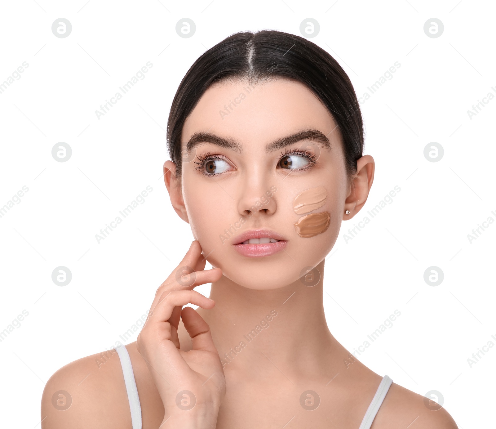 Photo of Teenage girl with swatches of foundation on face against white background