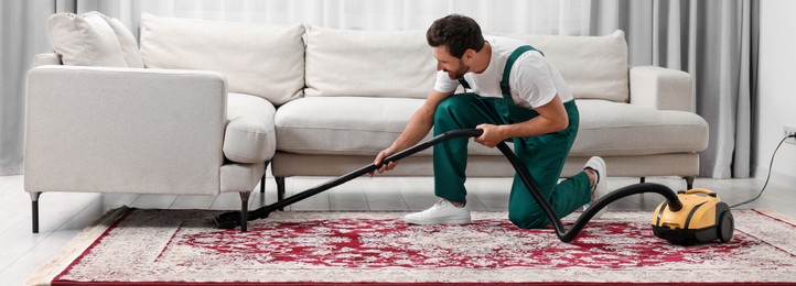 Dry cleaner's employee hoovering carpet with vacuum cleaner in room. Banner design