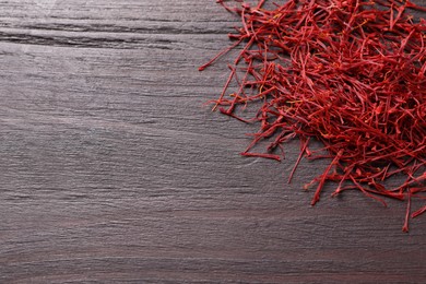 Dried saffron on wooden table, flat lay. Space for text