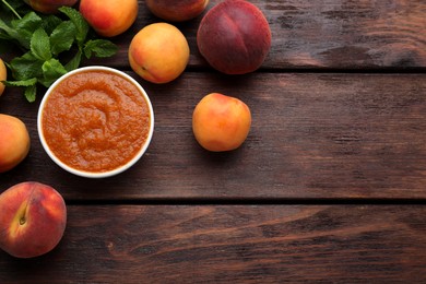 Photo of Apricot puree in bowl and fresh fruits on wooden table, flat lay. Space for text