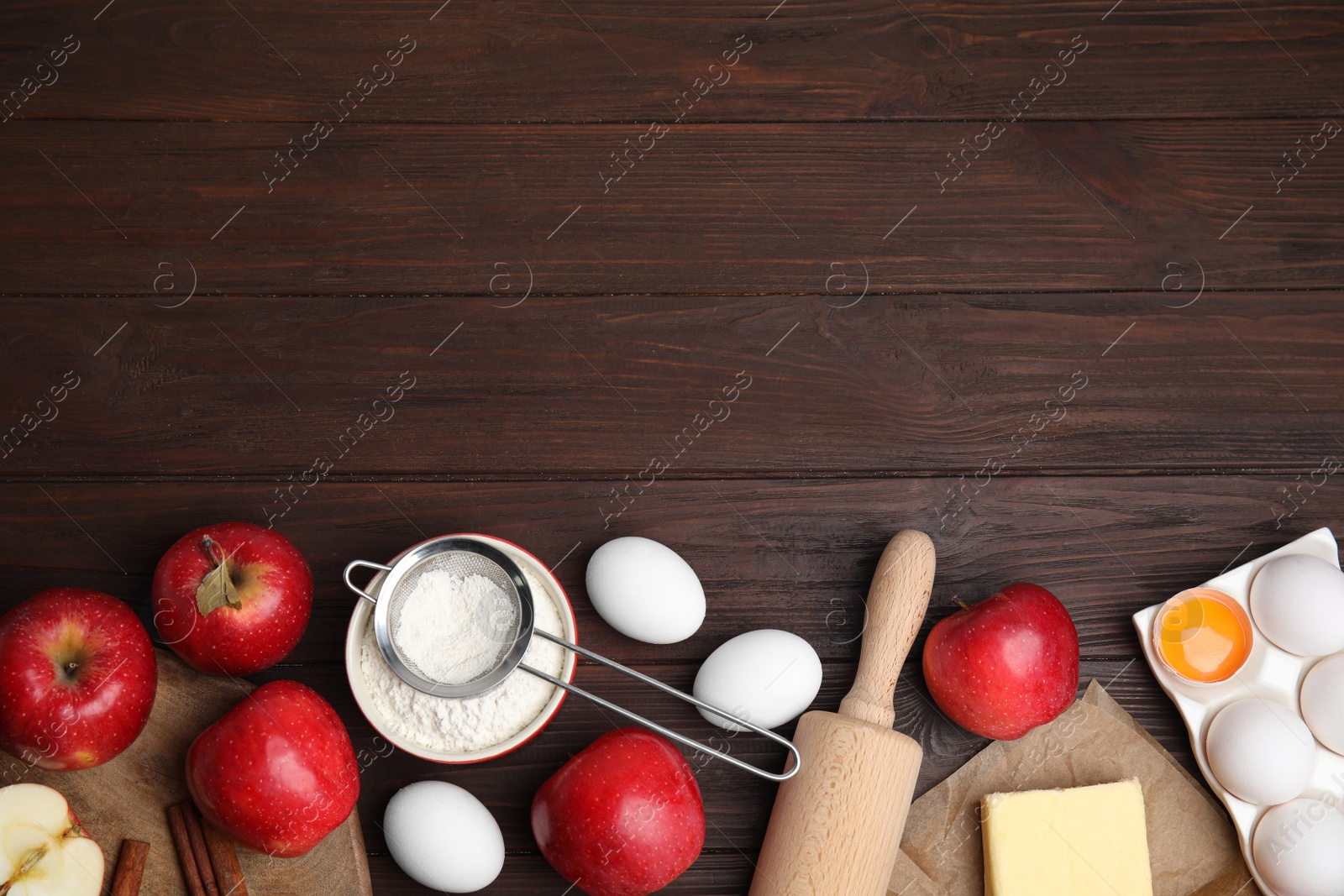 Photo of Traditional English apple pie ingredients on brown wooden table, flat lay. Space for text
