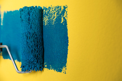 Photo of Painting yellow wall with blue dye, closeup view