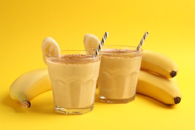 Photo of Tasty banana smoothie with chocolate and fresh fruits on yellow background