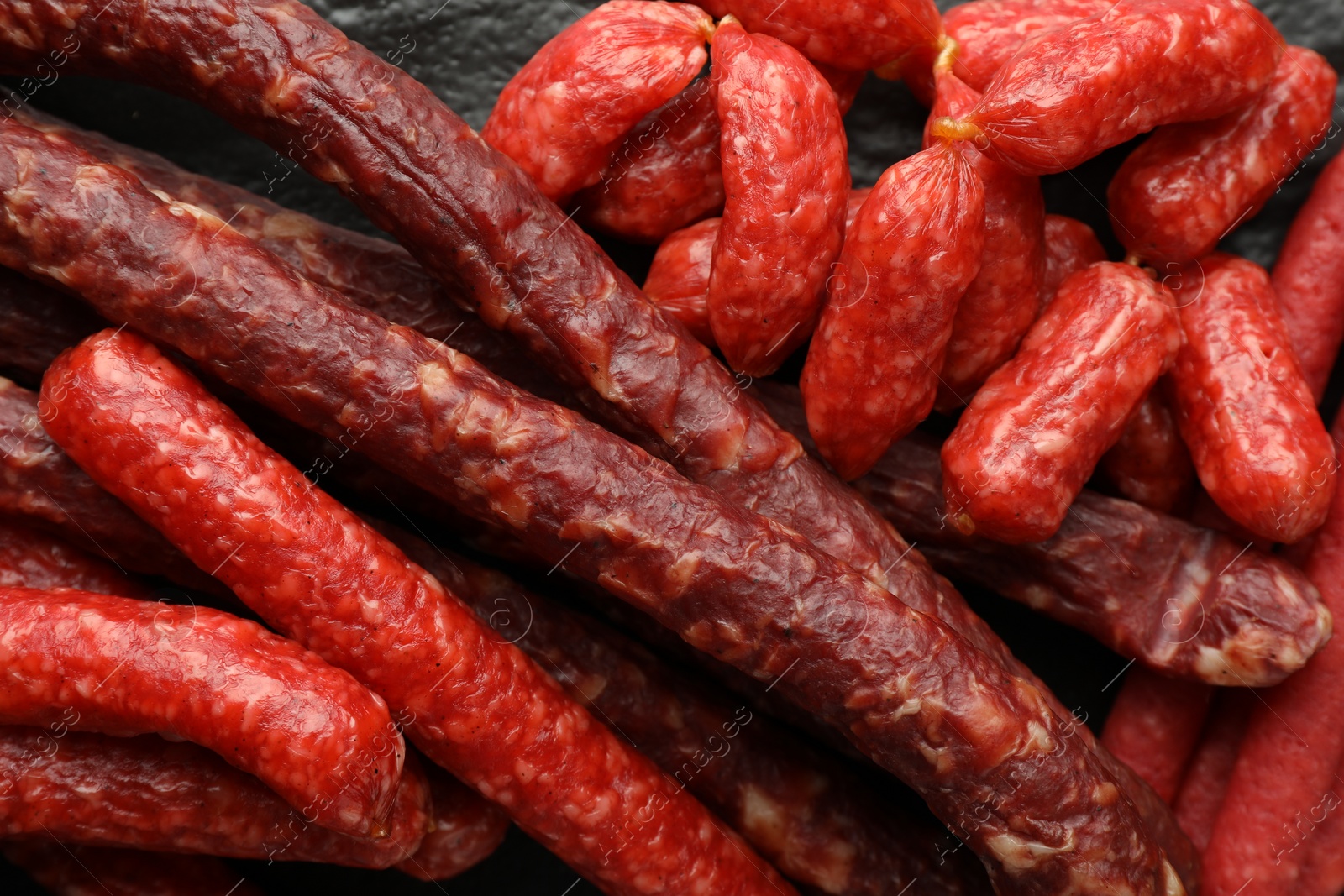 Photo of Many thin dry smoked sausages on table, top view