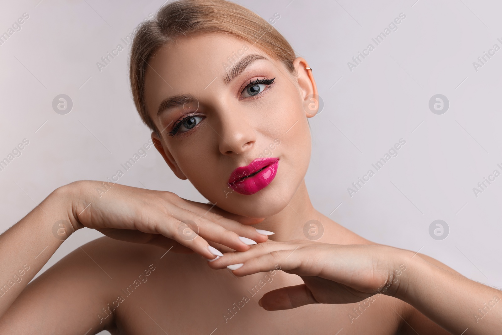 Photo of Beautiful young woman with perfect makeup on light grey background