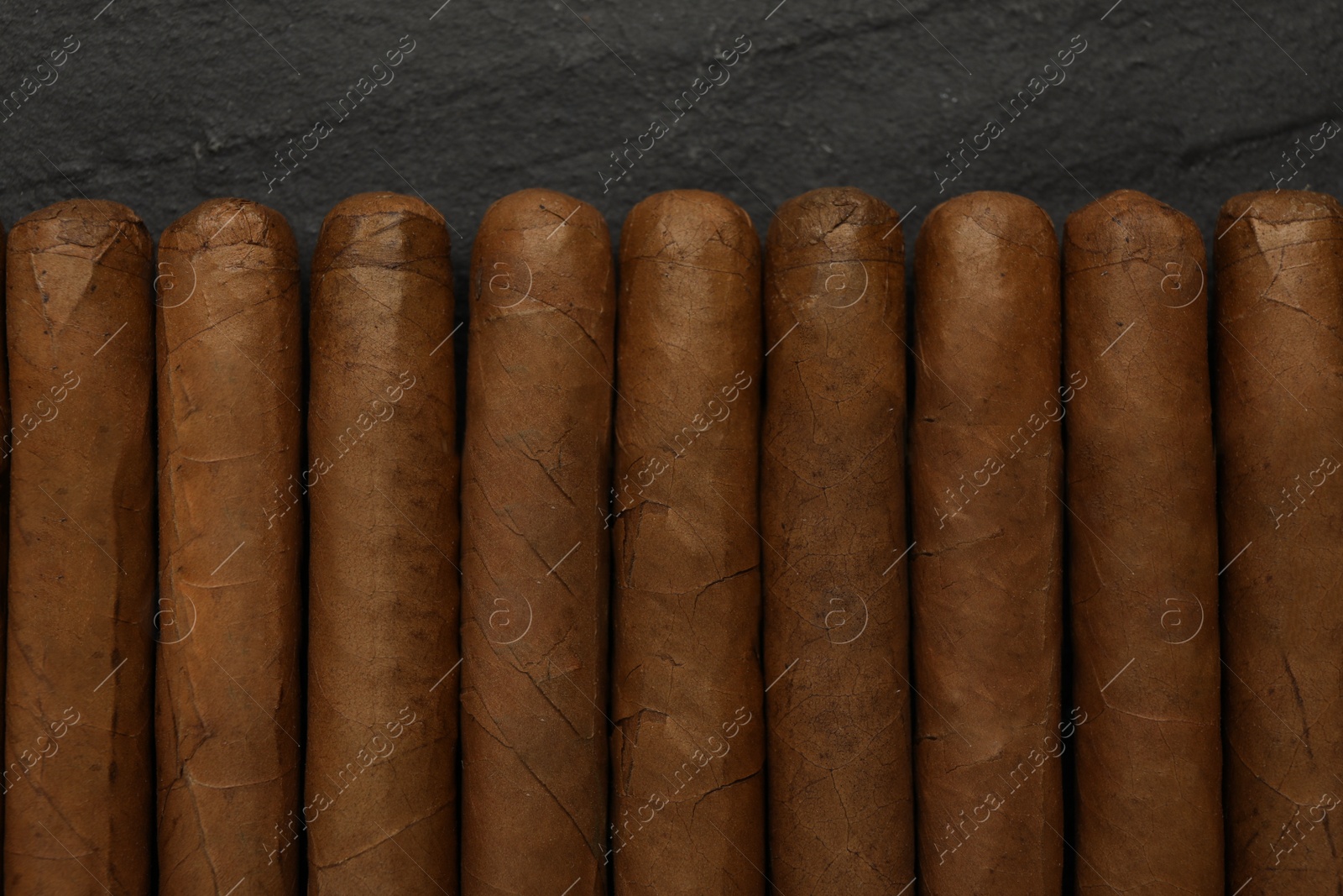 Photo of Many cigars on black table, flat lay