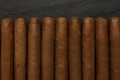 Many cigars on black table, flat lay