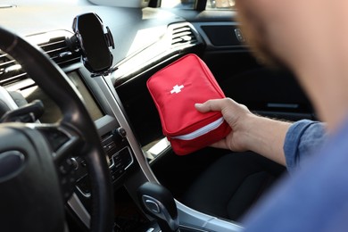 Photo of Man with first aid kit inside car, closeup