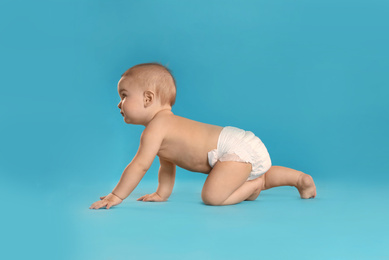 Cute little baby in diaper on light blue background