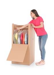 Photo of Young woman near wardrobe box on white background