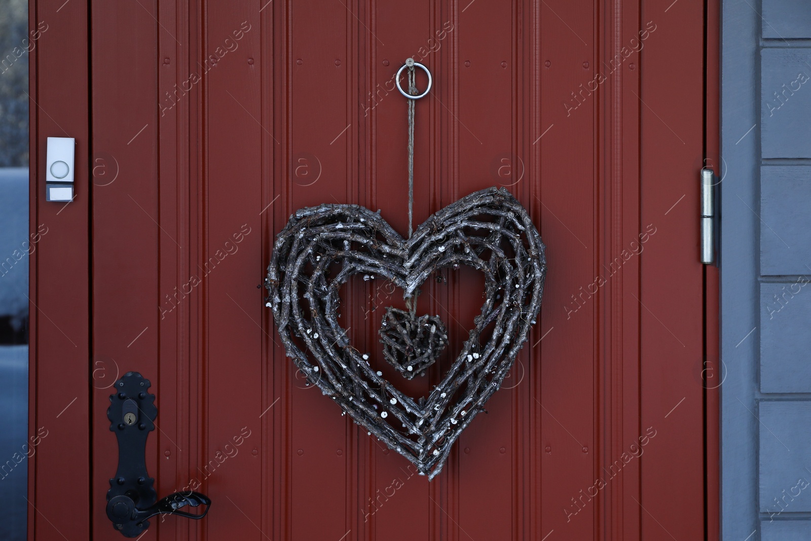 Photo of Beautiful heart shaped wreath made of twigs hanging on door