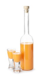 Photo of Bottle and shot glasses with tasty tangerine liqueur isolated on white