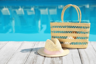 Beach accessories on wooden deck near outdoor swimming pool, space for text