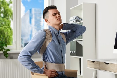 Photo of Man with orthopedic corset sitting in room