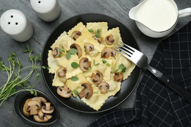 Photo of Delicious ravioli with mushrooms served on grey table, flat lay