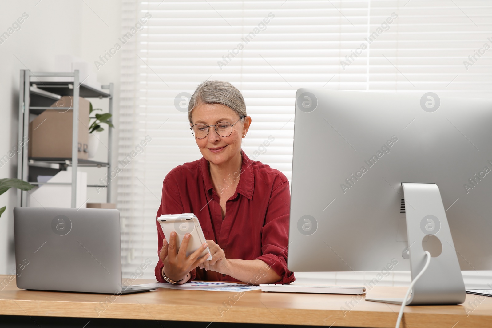 Photo of Senior accountant working at wooden desk in office