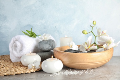 Composition with spa stones and candles on gray table