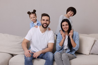 Photo of Portrait of happy family on sofa in living room