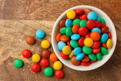 Tasty colorful candies on wooden table, flat lay