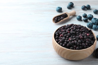 Freeze dried and fresh blueberries on white wooden table. Space for text