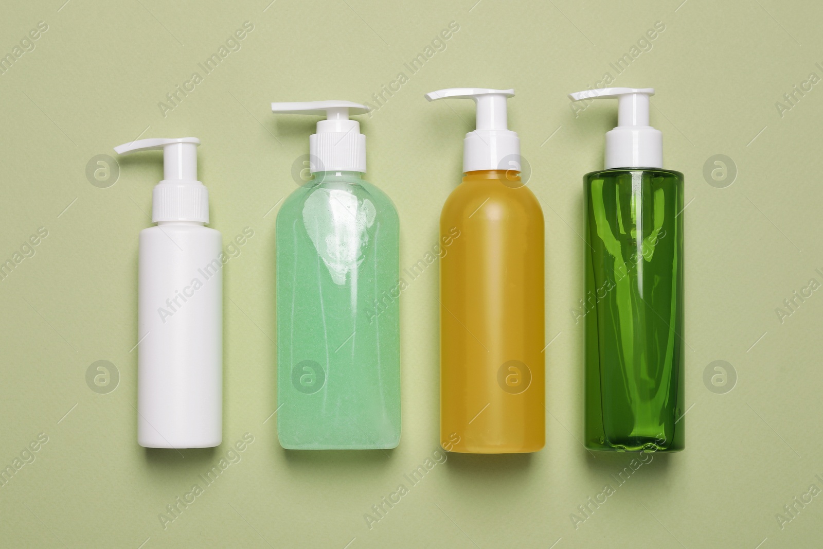 Photo of Different cleansers on olive background, flat lay with space for text. Cosmetic product