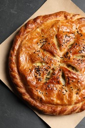 Tasty homemade pie with filling on grey table, top view