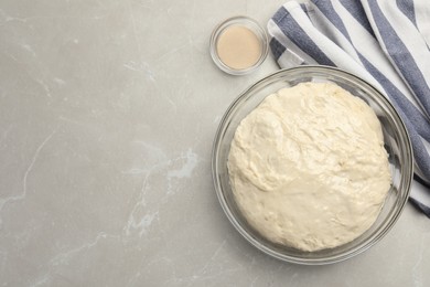 Fresh dough for cake and dry yeast on marble table, flat lay. Space for text