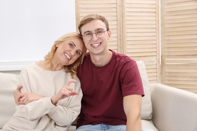 Photo of Mother and son spending time together on sofa at home. Family bonding