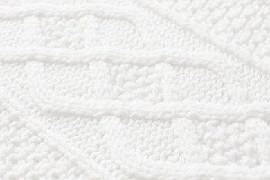 White knitted fabric with beautiful pattern as background, closeup