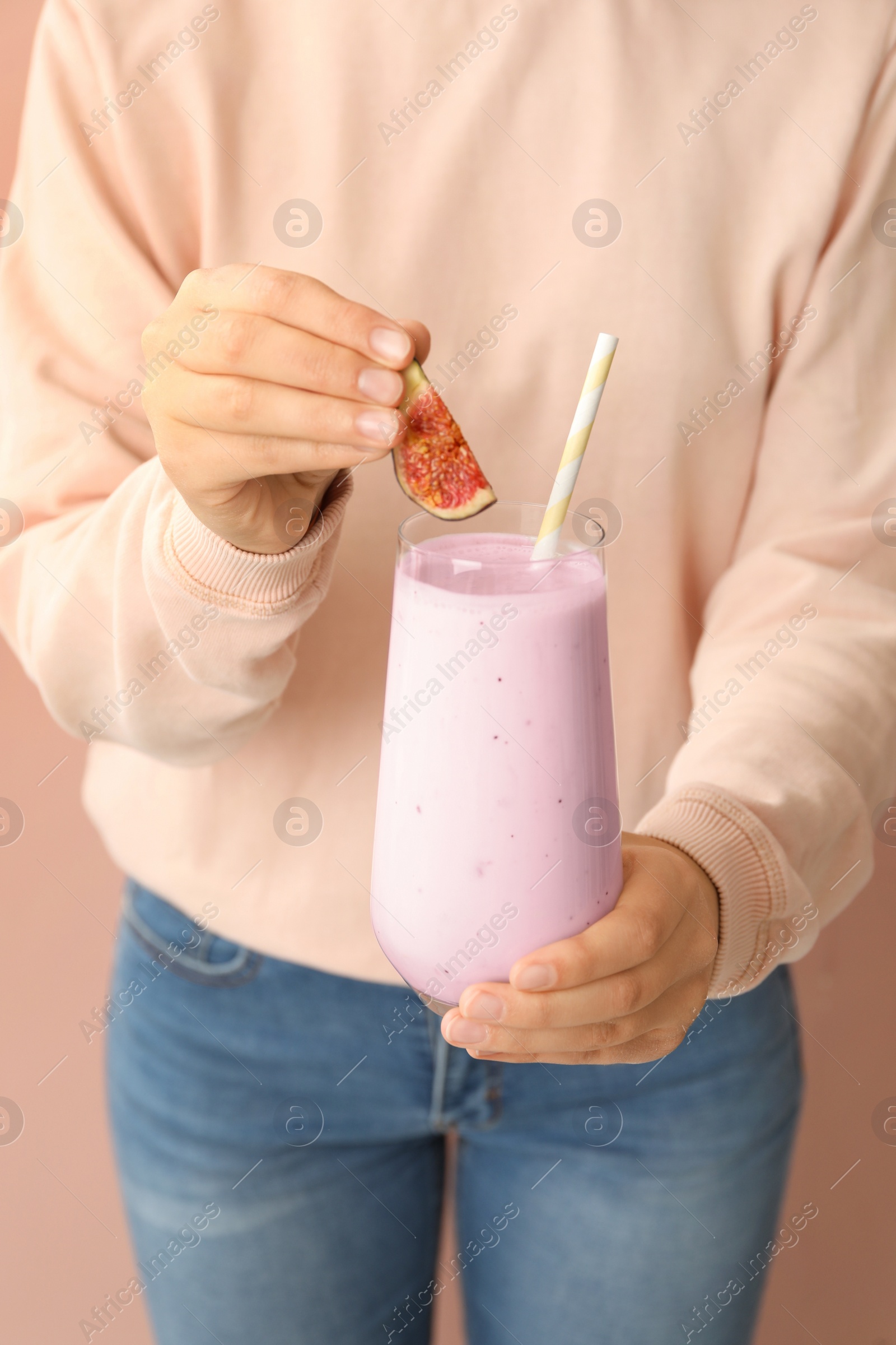 Photo of Woman holding fig smoothie on pink background, closeup