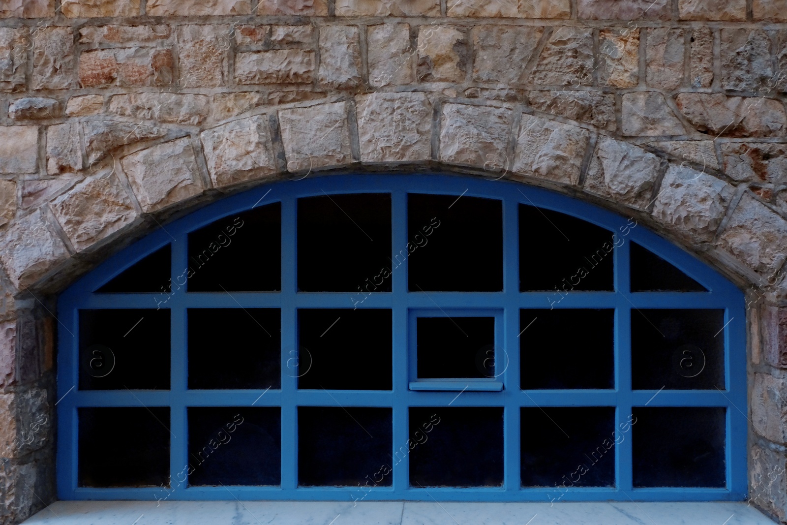 Photo of View of old arch window in stone wall, closeup