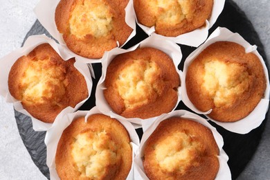 Delicious sweet muffins on grey textured table, top view