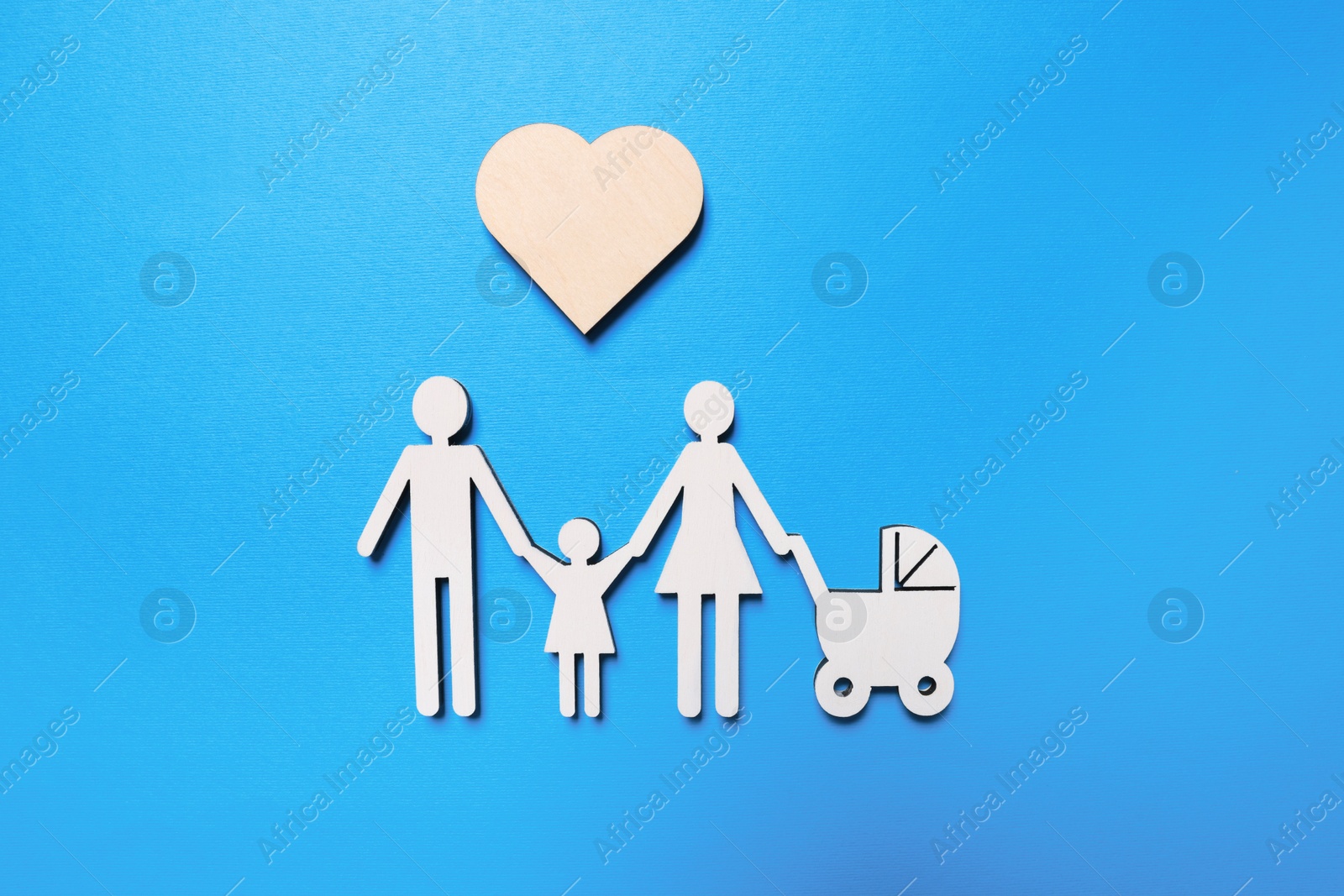 Photo of Figures of family and heart on light blue background, flat lay. Insurance concept