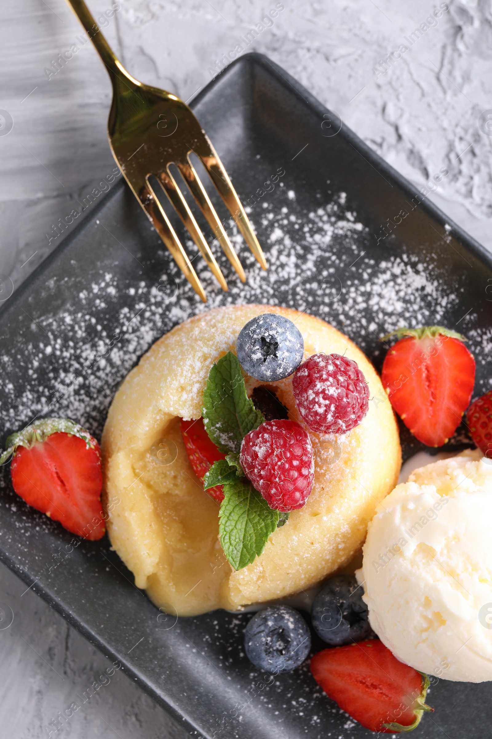 Photo of Tasty vanilla fondant with white chocolate, berries and ice cream on light grey textured table, flat lay