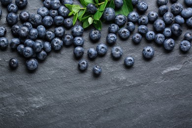 Photo of Tasty fresh blueberries on grey table, flat lay. Space for text