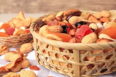 Photo of Mixed dried fruits and nuts on checkered tablecloth, closeup