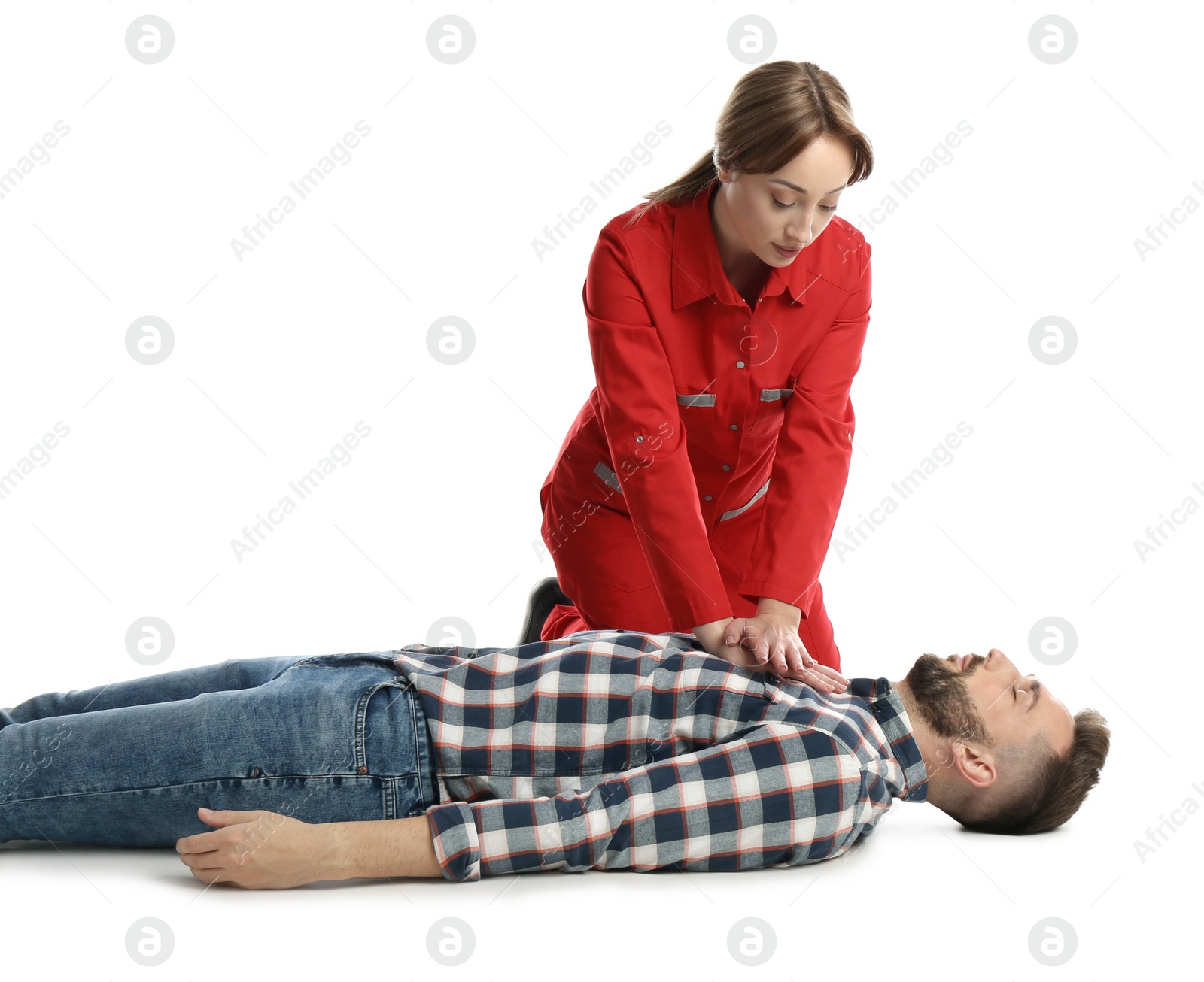 Photo of Paramedic in uniform performing first aid on unconscious man against white background