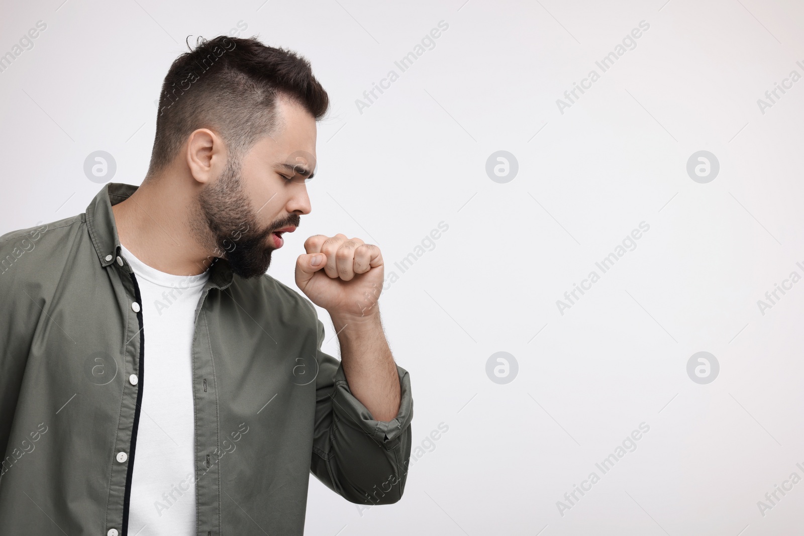 Photo of Sick man coughing on white background, space for text